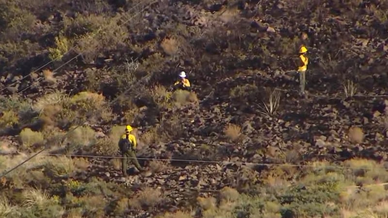 Firefighters hosing down side of the mountain due to Crest Way Fire