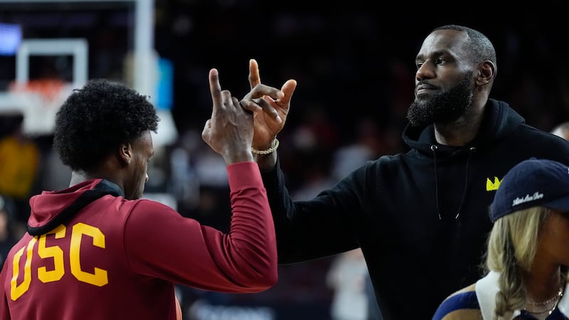 Southern California guard Bronny James, left, high-fives his father, Los Angeles Lakers'...