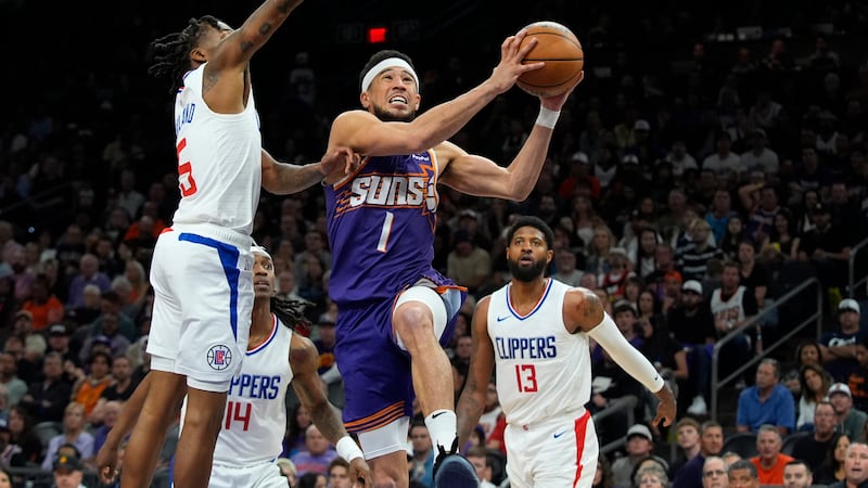 Phoenix Suns guard Devin Booker (1) drives past Los Angeles Clippers guard Bones Hyland, left,...
