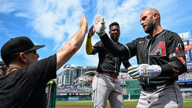 Arizona Diamondbacks manager Torey Lovullo, left, congratulates Diamondbacks' Christian Walker...