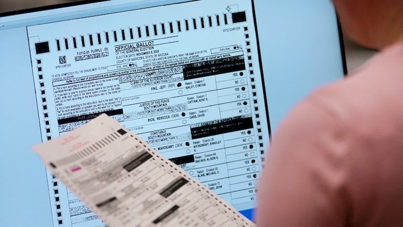FILE - An election worker verifies a ballot on a screen inside the Maricopa County Recorders...