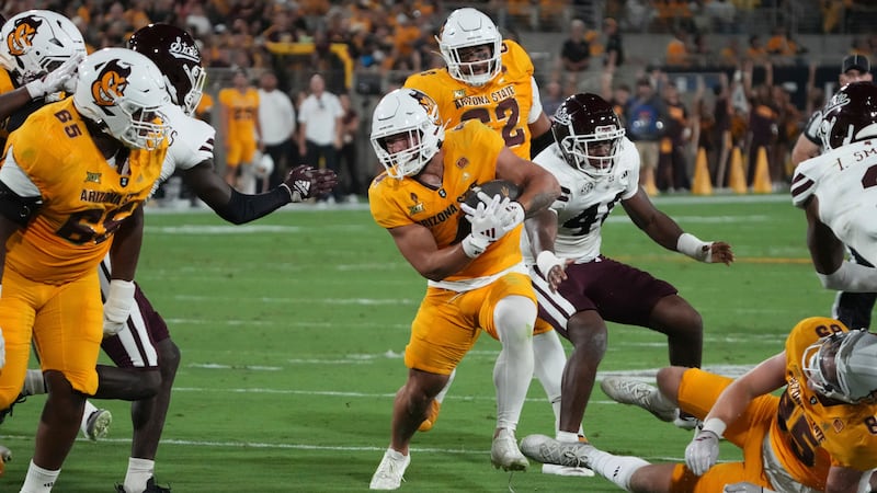 Arizona State running back Cam Skattebo, center front, runs the ball against Mississippi State...